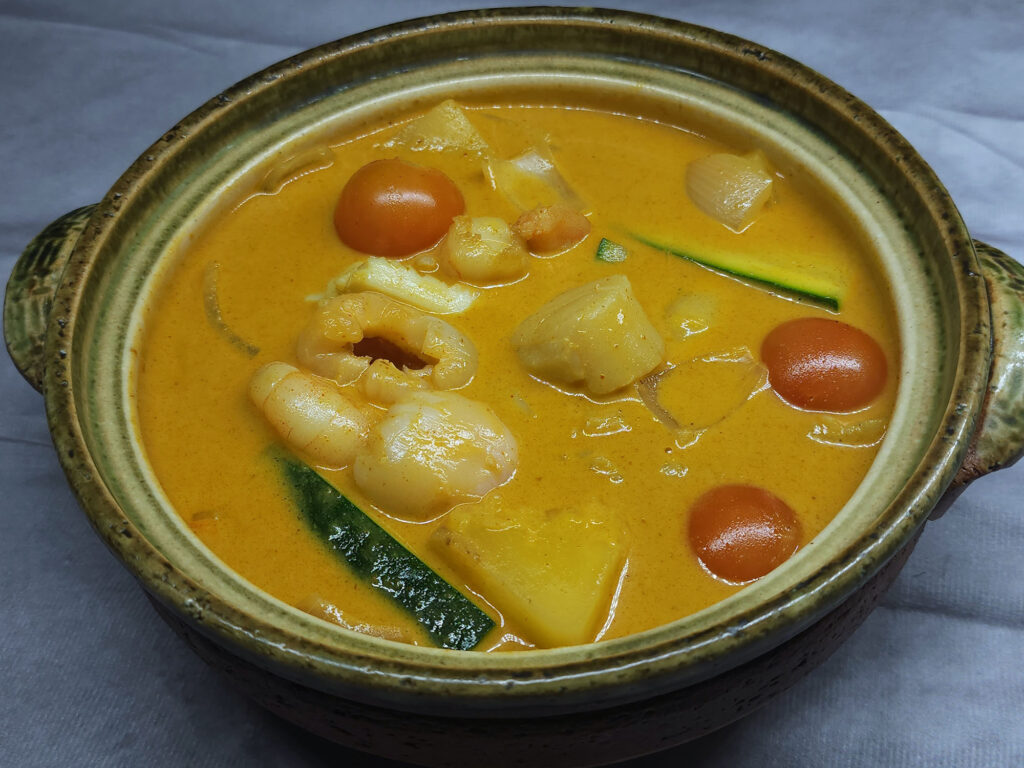 B7 Seafood combination with signature yellow curry sauce in clay pot