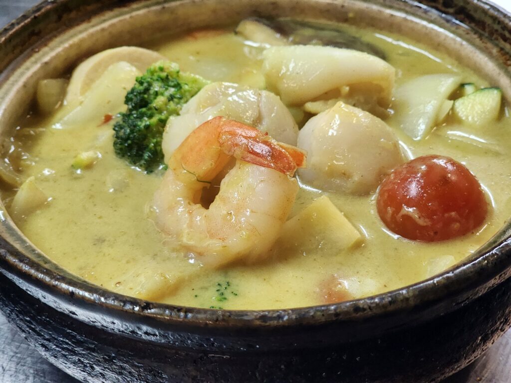 B7 Seafood combination with signature yellow curry sauce in clay pot